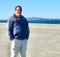 Picture of self standing on the beach with Port Townsend in the background.